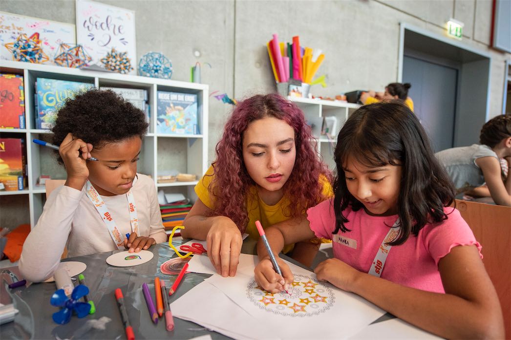 Mitarbeitende und Kinder beim Basteln